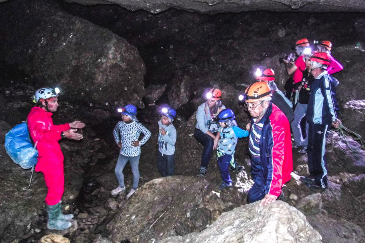 personas con linternas en el casco en la cueva de los apas