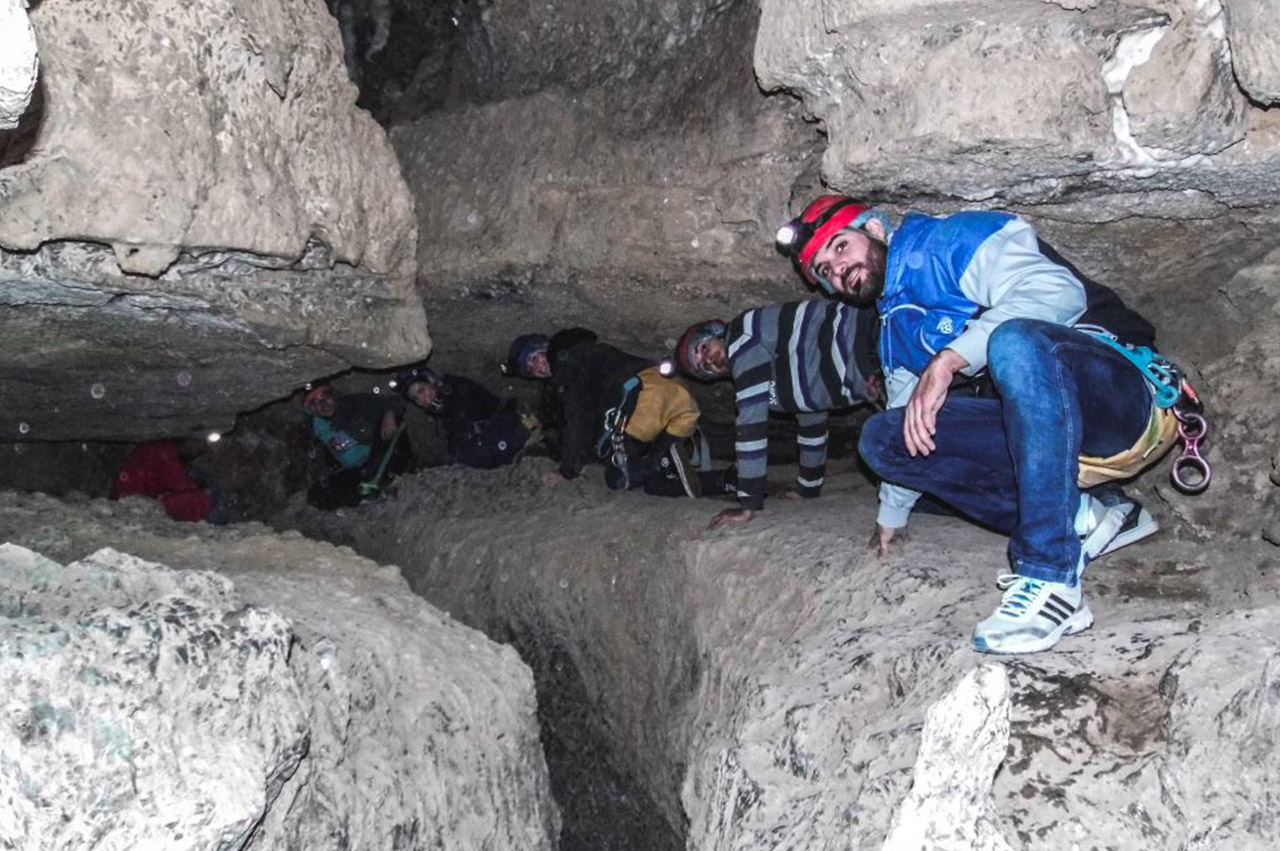 grupo de personas agachadas en la cueva del tesoro